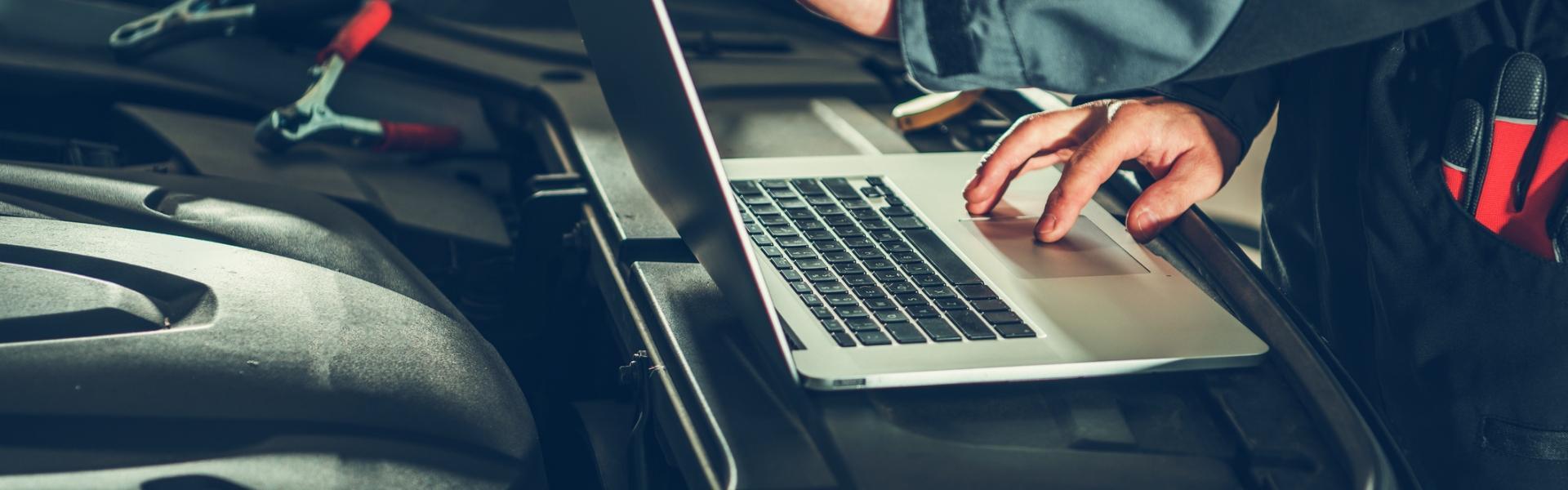 Mechanik podłączający laptopa do samochodu
